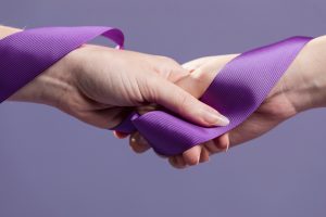 women-hands-holding-purple-satin-ribbon